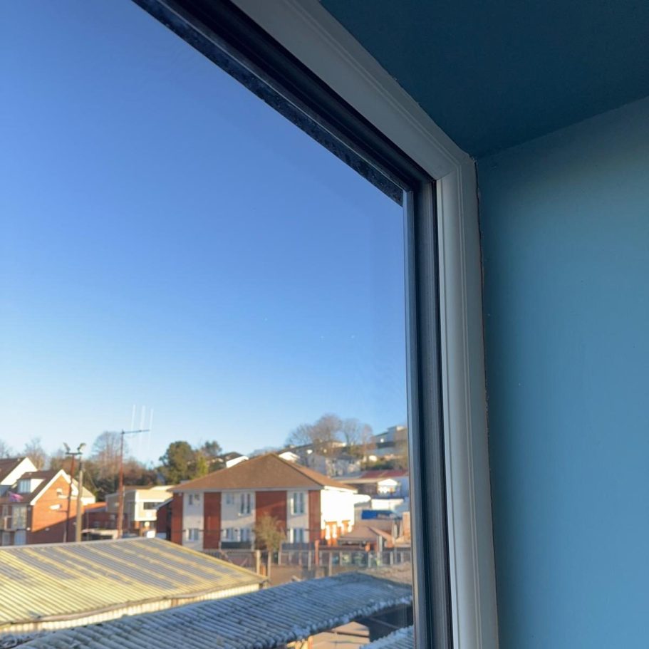 Commercial Deep Cleaning – After Photo | Window View from a window featuring blue sky and rooftops of nearby houses.