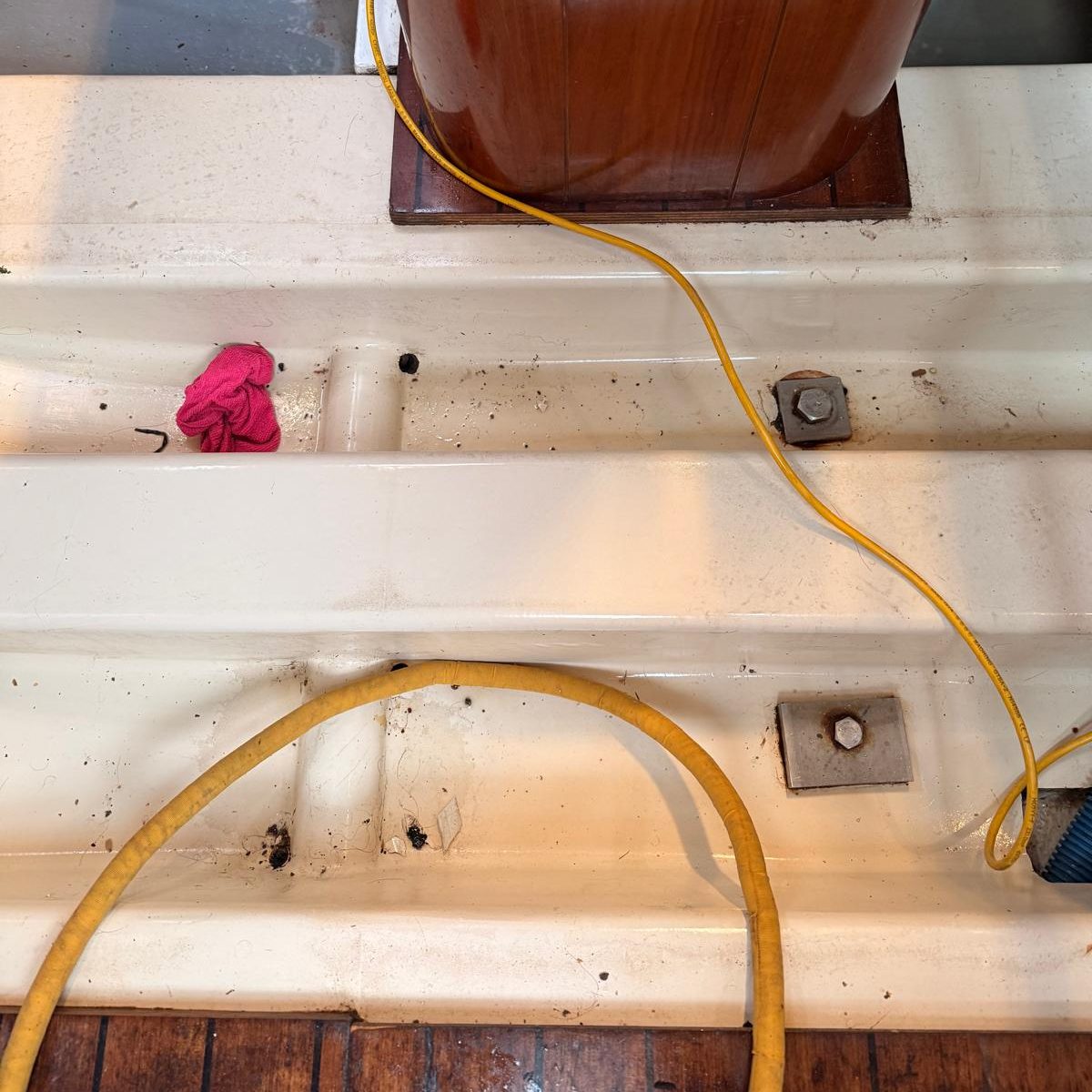 Commercial Cleaning – Industrial | Before Photo | Dirty A wooden platform with a yellow cord, a pink cloth, and small metal fixtures.