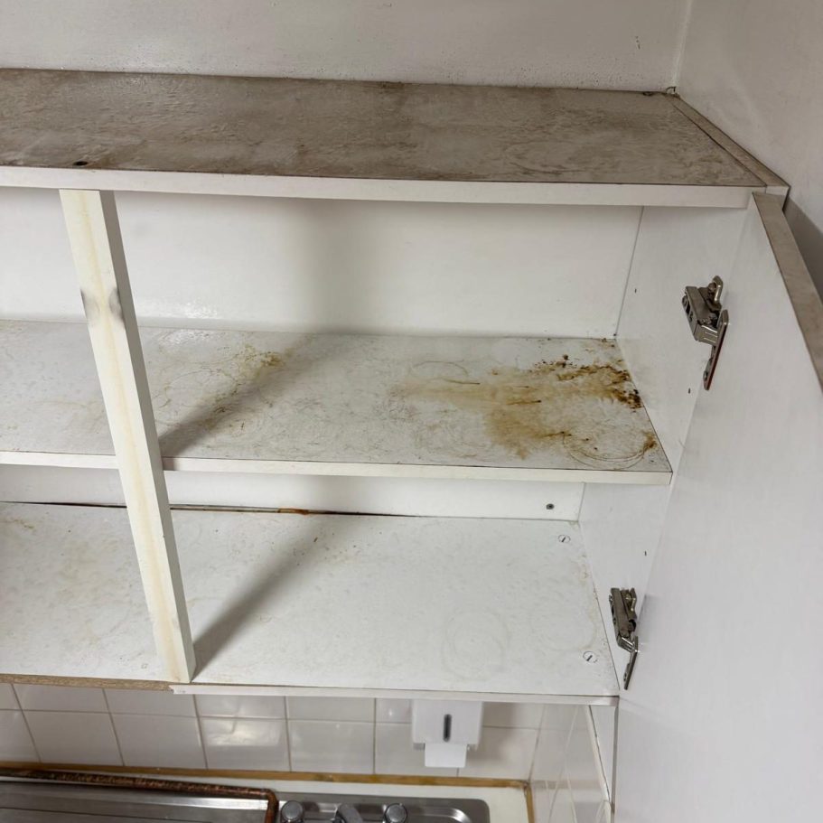 Commercial Cleaning | Before Photo | Cupboards Dirty kitchen cupboard with stained shelves and visible wear.